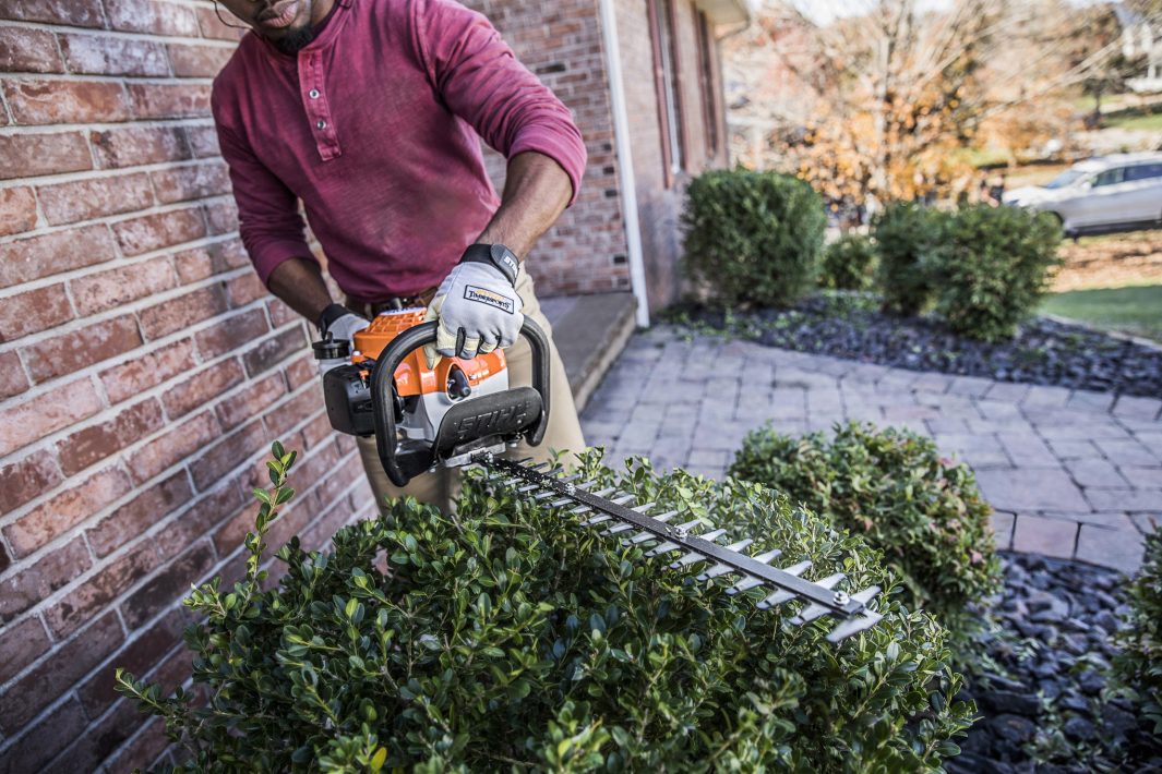 Nożyce spalinowe STIHL HS 45 – osoba przycina żywopłot w ogrodzie, autoryzowany dealer Techfix Radom